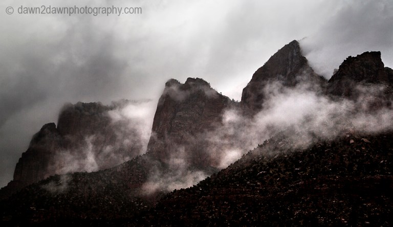 Passing storms bring rain and fog to the steep sandstone canyon walls at Zion National Park, Utah