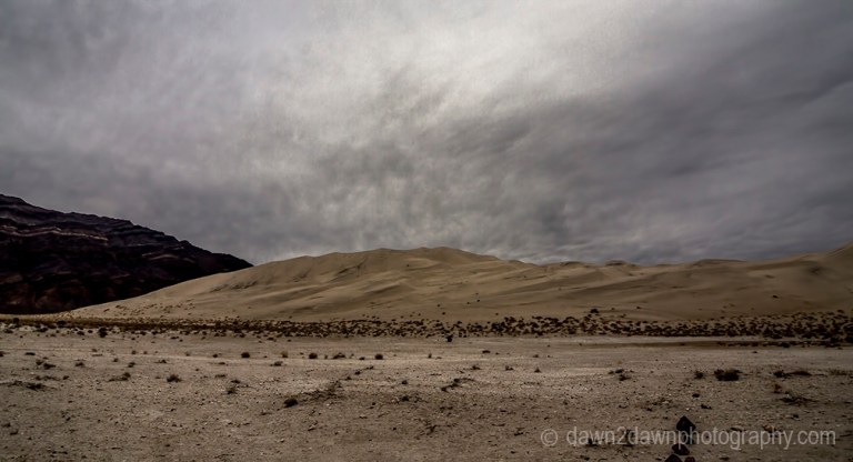 The sun struggles to appear through the clouds at Eureka Dunes at Death Valley National Park, California