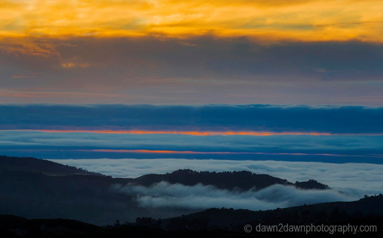 The sun sets beyond the approaching marine layer at Carmel Valley, California