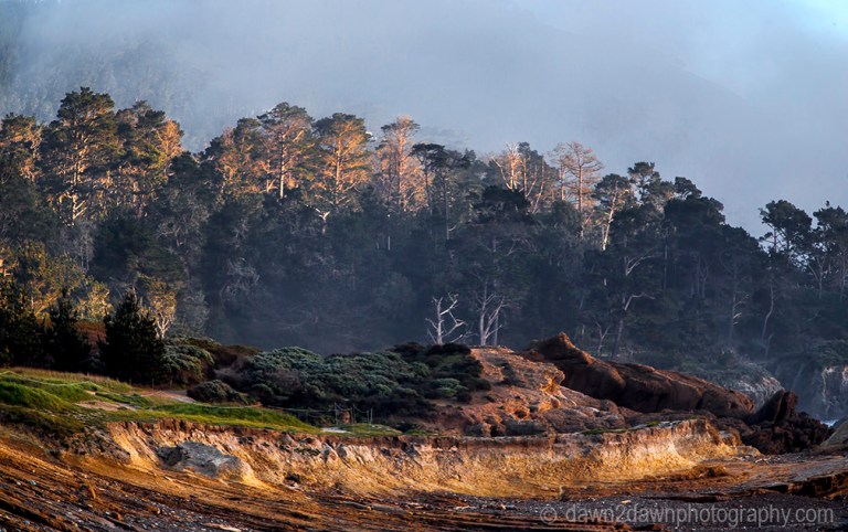 The sun sets on the rocky landscape at Point Lobos State Natural Reserve in Carmel, California