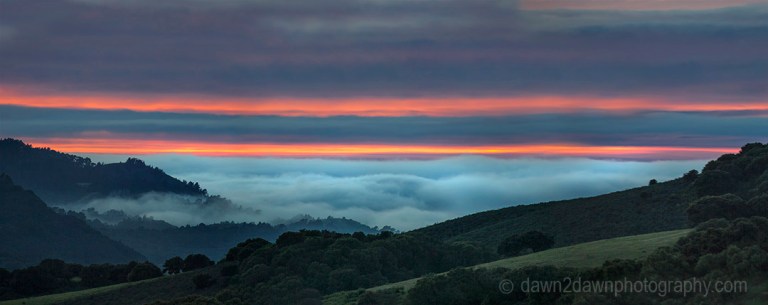 The sun sets beyond the approaching marine layer at Carmel Valley, California
