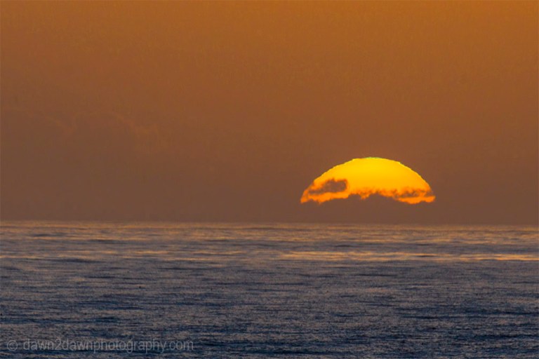 The sun sets on California's Pacific Ocean at San Simeon.