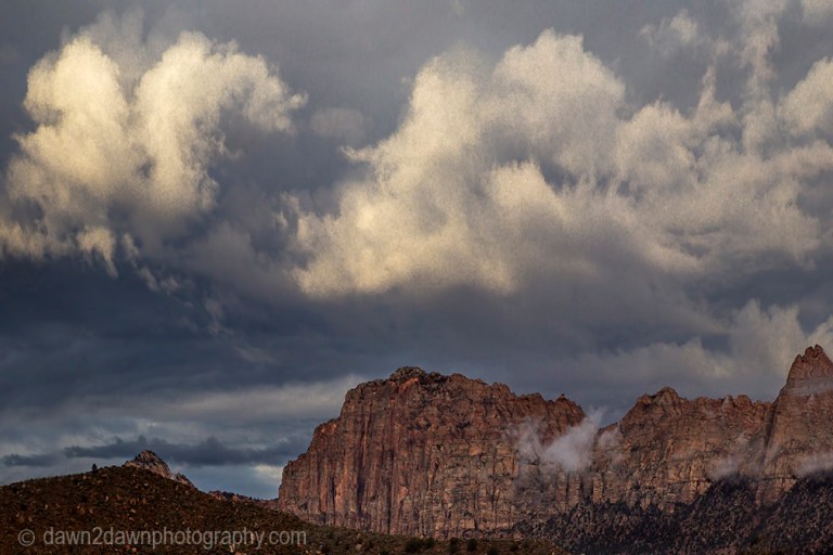 A passing storm produces clouds around The Watchman at Zion National Park, Utah
