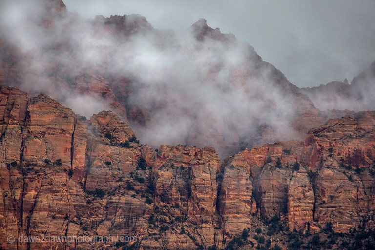 A passing storm produces clouds around The Watchman at Zion National Park, Utah