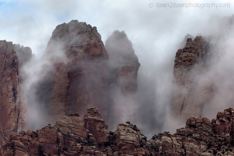A passing thunderstorm deposits clouds around West Temple at Zion National Park, Utah