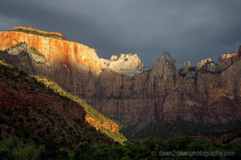 The light from the rising sun shines upon The Towers Of The Virgin at Zion National Park, Utah