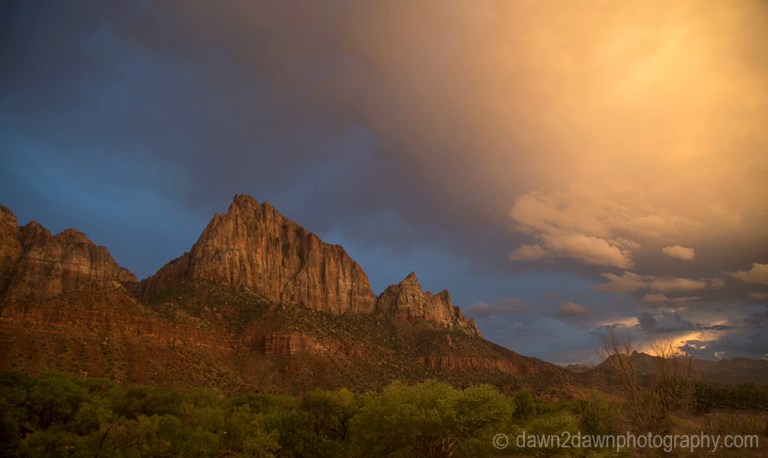 The light from the setting sun shines on the The Watchman at Zion National Park, Utah
