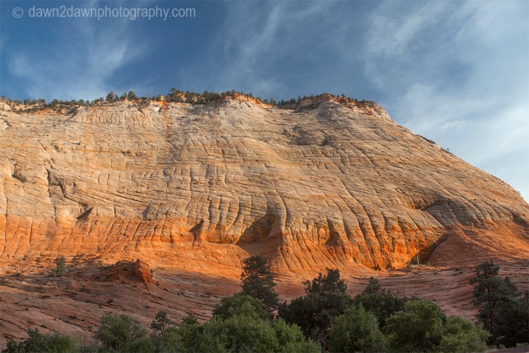 The light from the setting sun shines upon "Crazy Quilty Mesa" at Zion National Park, Utah