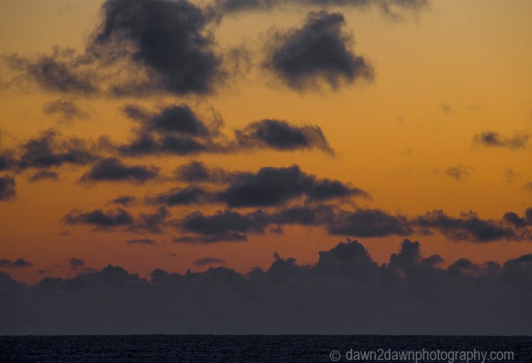 The light from the setting sun casts a soft light on clouds over the Pacific Ocean at California's central coast.