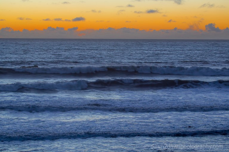 The light from the setting sun casts a soft light on clouds over the Pacific Ocean at California's central coast.