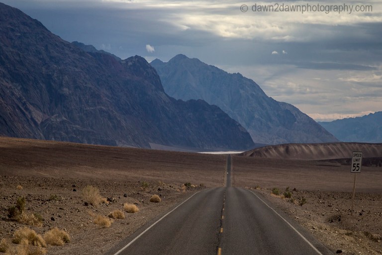 Passing storm clouds filter sunlight on the landscape at Badwater Basin at Death Valley National Park, California